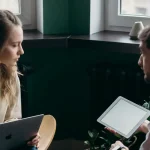 ノートPCとタブレットを使って会話する男女