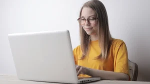 ノートパソコンの前の眼鏡をかけた女性